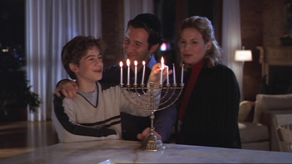 Alex Schlotsky lighting menorah by his parents